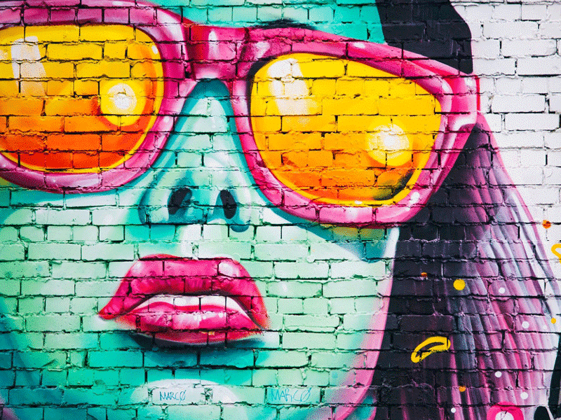 Grafik von Frau mit Sonnenbrille auf Mauer